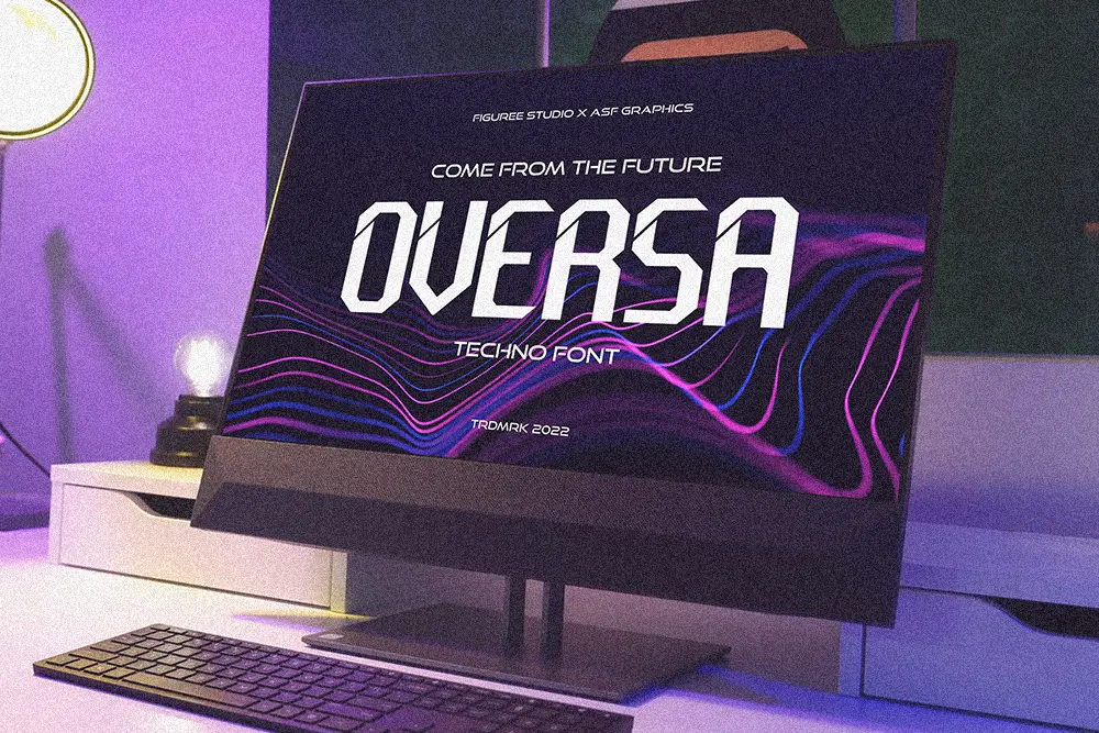 A desktop monitor displays the word "Oversa" in a futuristic techno font, surrounded by purple and blue wavy lines, set in a modern workspace with ambient lighting.